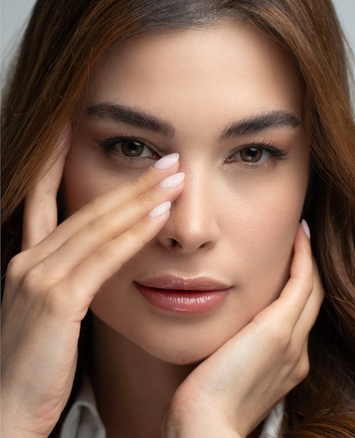Close-up portrait of an adult woman with natural beauty and elegant makeup.
