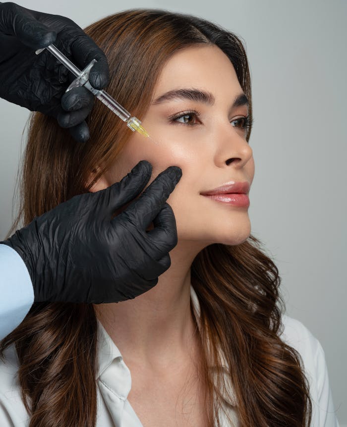 A dermatologist administers a dermal filler injection to a woman's face, enhancing facial aesthetics.
